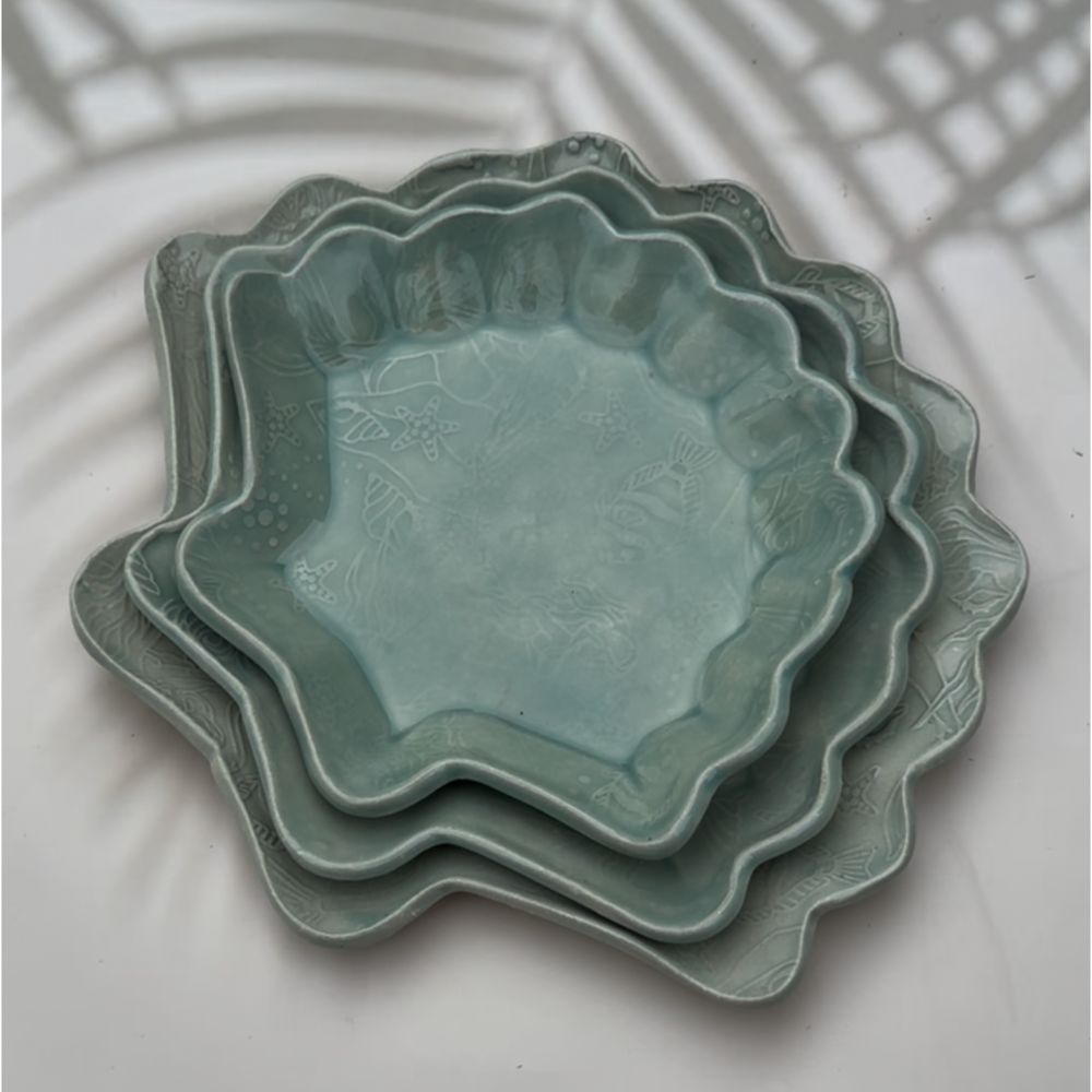 stackable ceramic shell plates showcase a textured ocean print featuring turtles