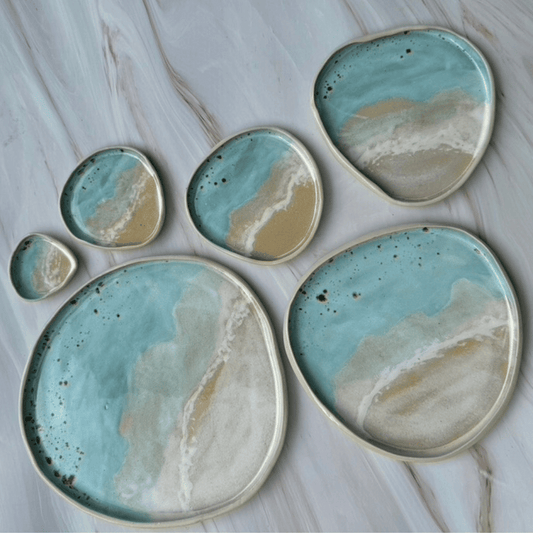 Set of ceramic plates with blue and beige glaze on a marble surface