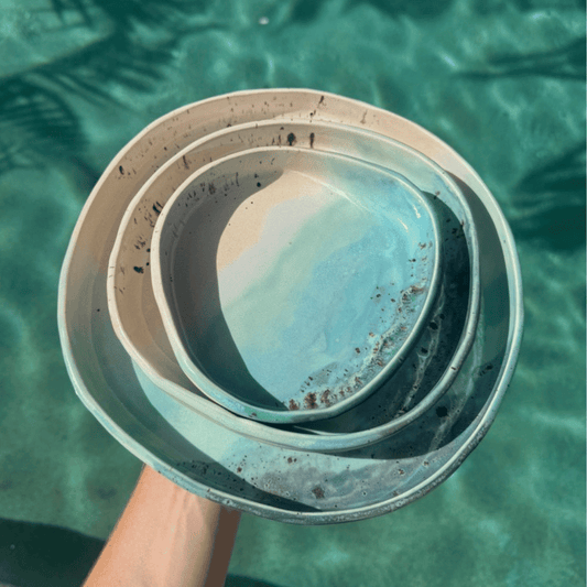 Stack of nesting ceramic blates held over a pool with clear water. Sunshine Pot-Tree, Sunshine Coast Queensland Australia