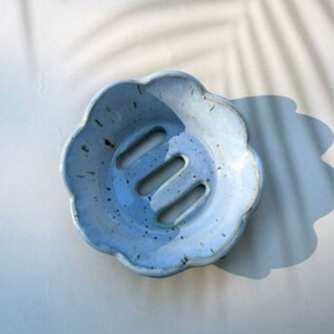 Blue ceramic soap dish with floral design on a light background