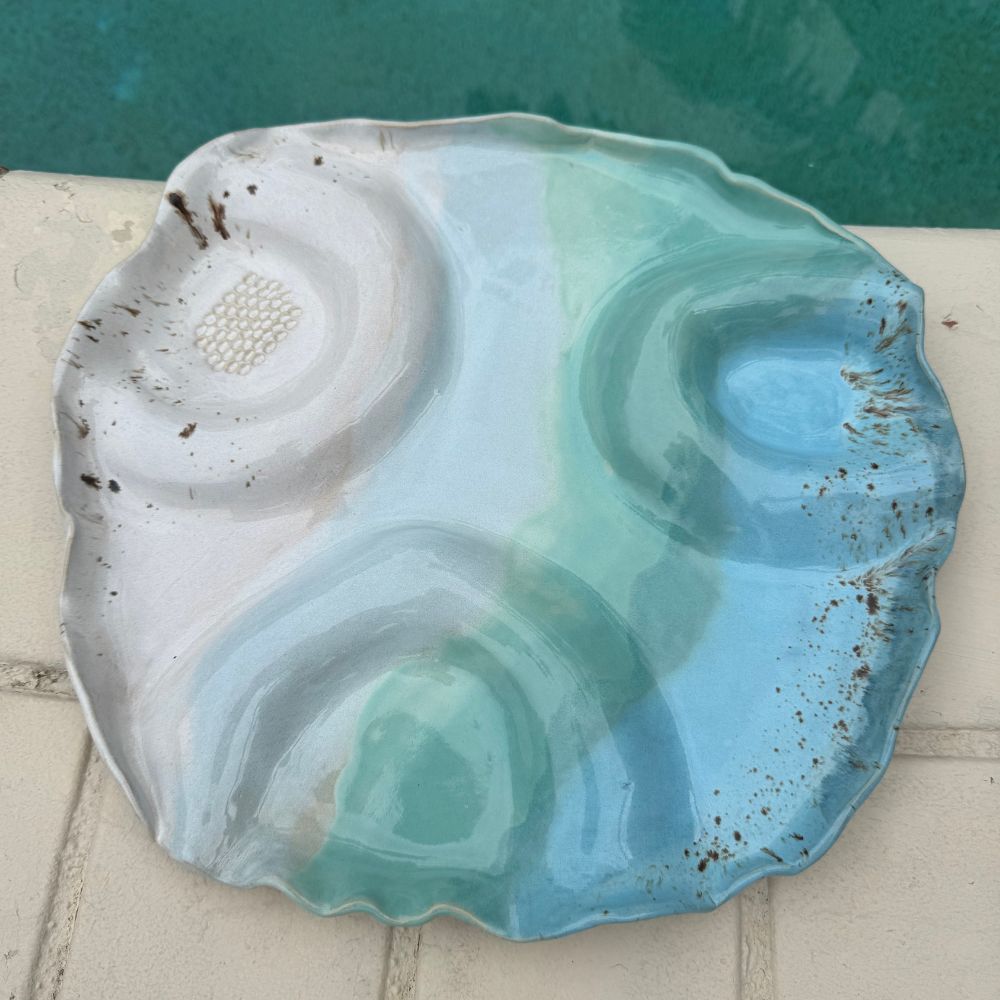 Decorative ceramic dish with blue and white design on a tiled surface.