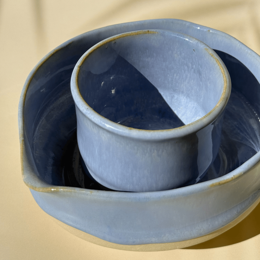 Blue ceramic dish with a smaller bowl inside on a beige background