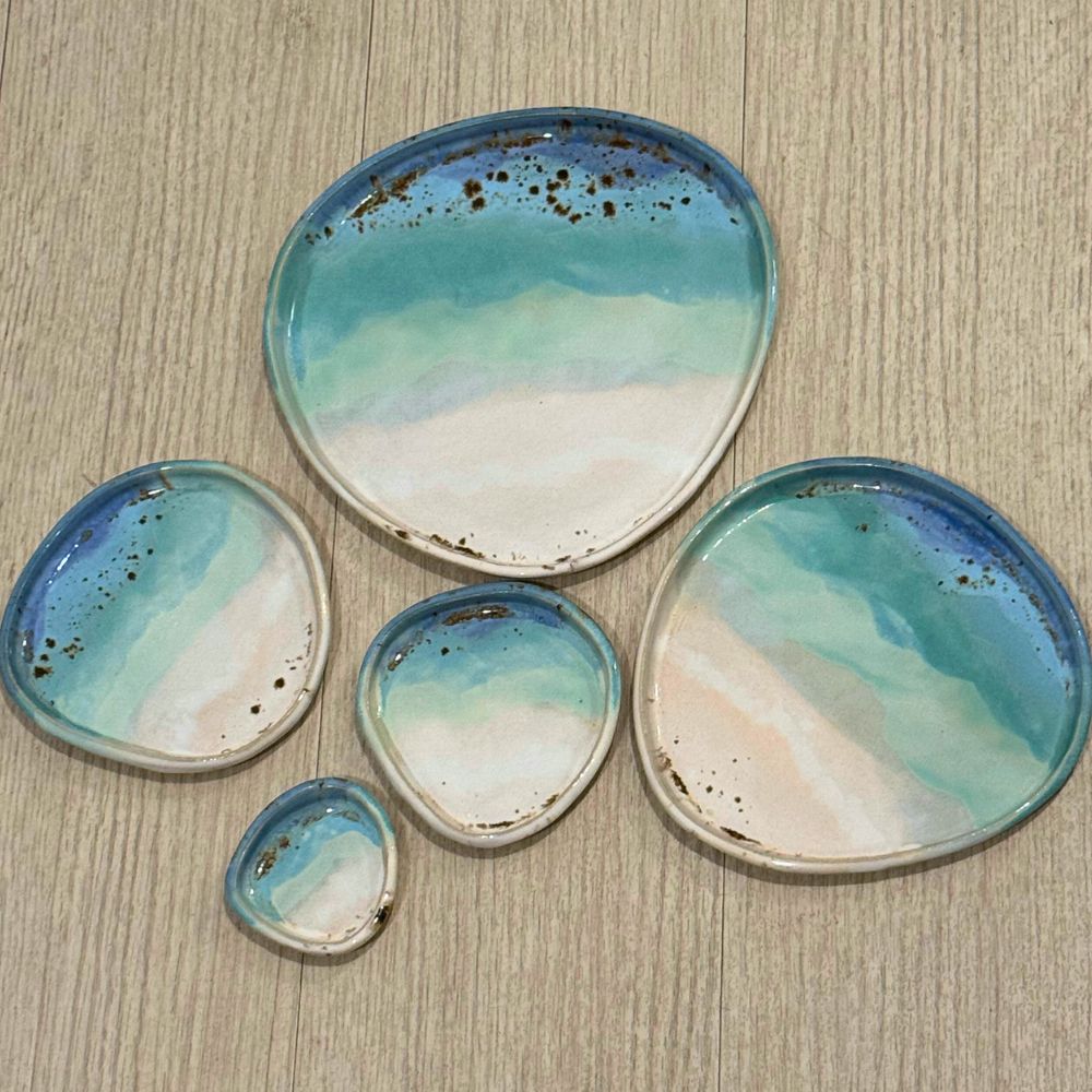 Set of ceramic dishes with blue and white glaze on a wooden surface