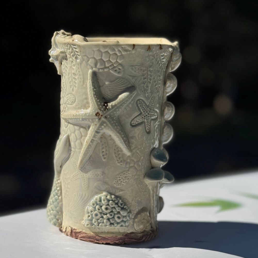 Ocean Shells Ceramic Vase with detailed sea-inspired textures including starfish, shells, and coral in a soft seafoam glaze. Ideal for coastal home decor.