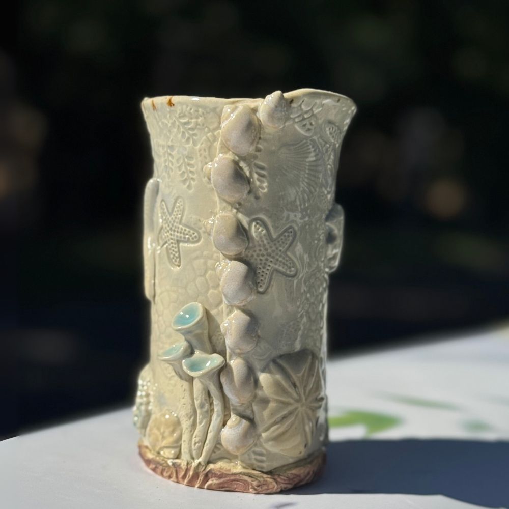 Ocean Shells Ceramic Vase with detailed sea-inspired textures including starfish, shells, and coral in a soft seafoam glaze. Ideal for coastal home decor.