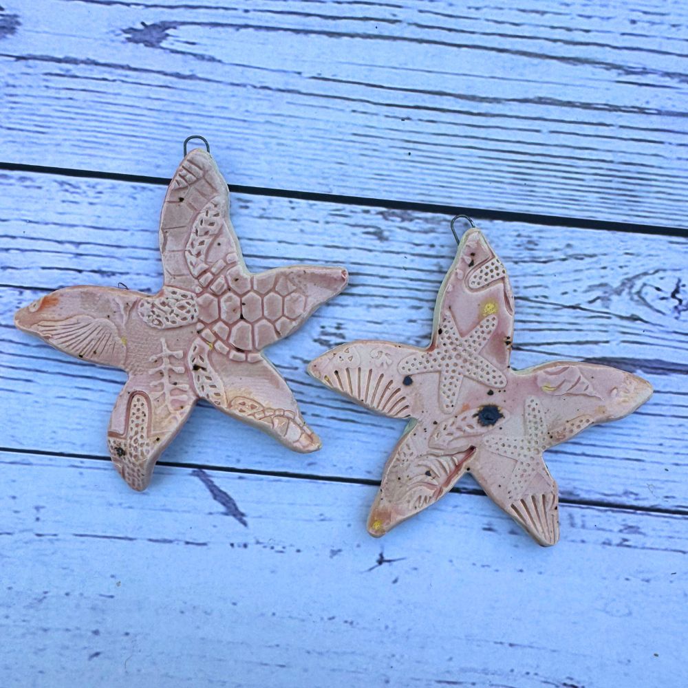 Two ceramic starfish on a wooden surface