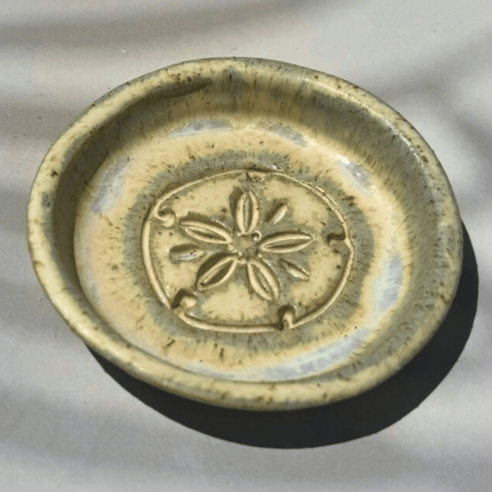 Decorative ceramic trinket dish with a floral design on a gray background