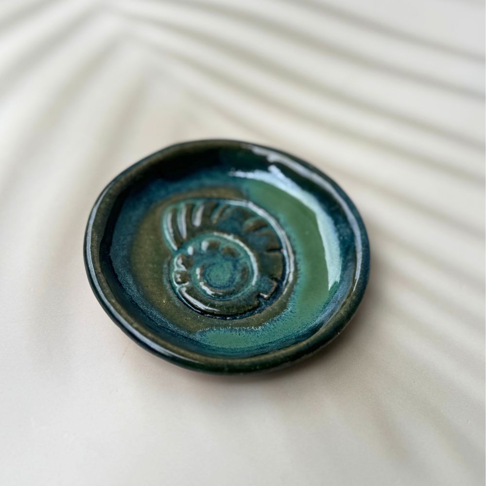Artisan ceramic trinket dish with teal blue glaze inspired by the ocean