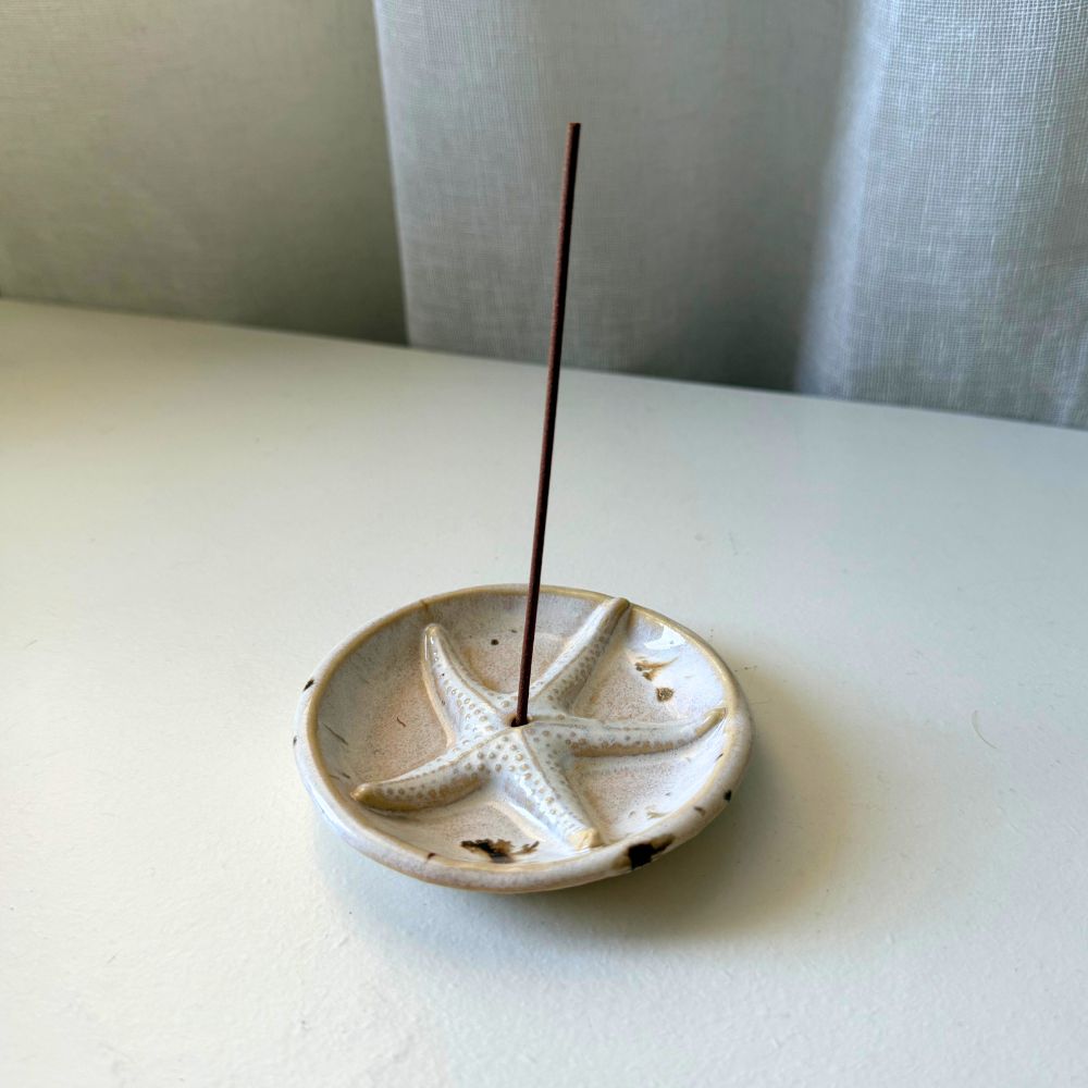 Ceramic incense holder with starfish design on a white surface