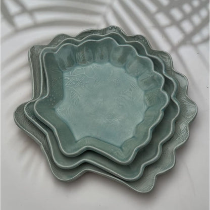 stackable ceramic shell plates showcase a textured ocean print featuring turtles