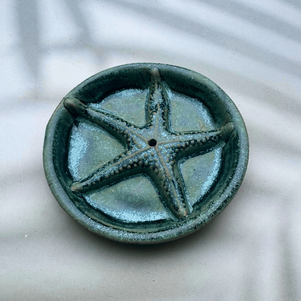 Ceramic dish with starfish design on a textured surface