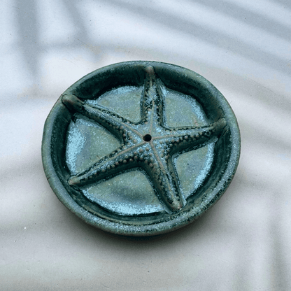 Ceramic dish with starfish design on a textured surface