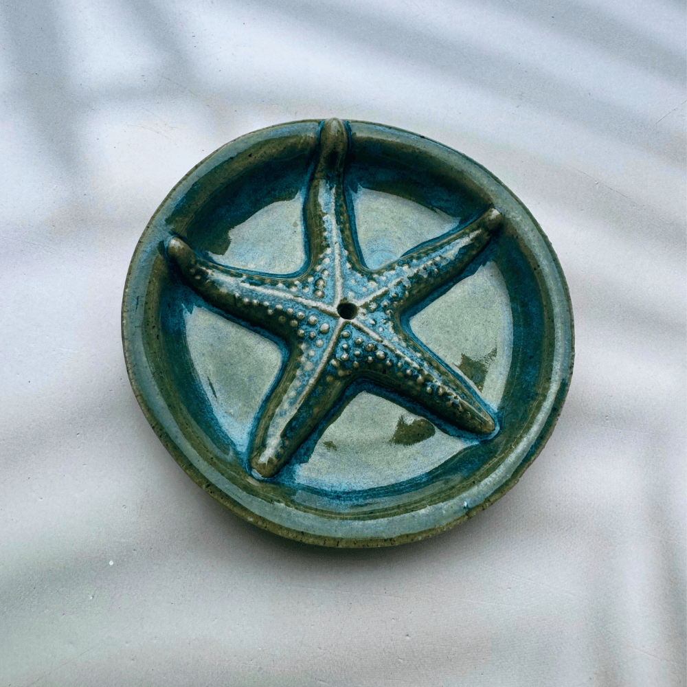 Ceramic incense holder with a starfish design on a marble surface