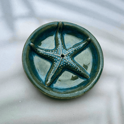 Ceramic incense holder with a starfish design on a marble surface