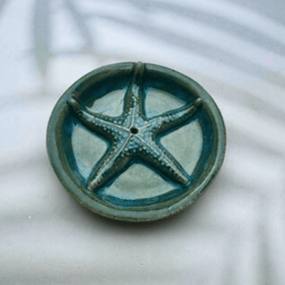 Ceramic incense holder with starfish design on a white background