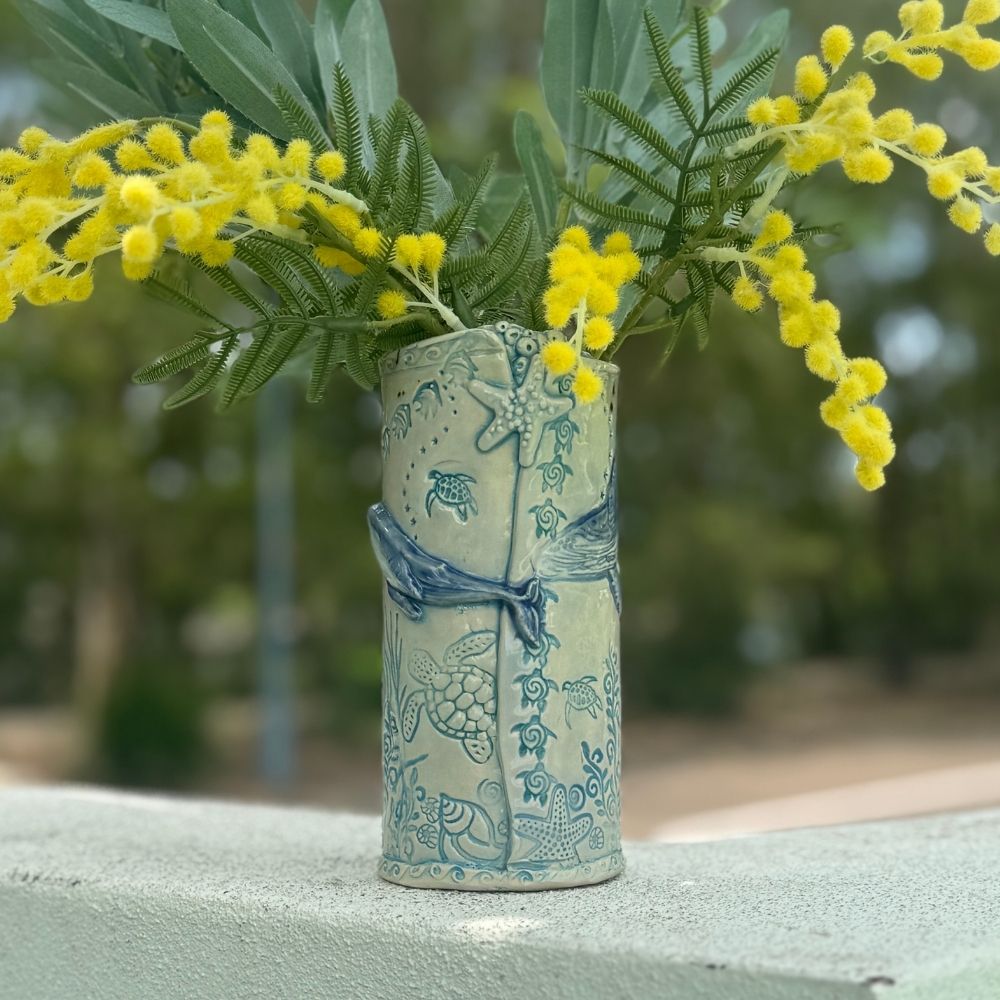 Decorative vase with floral arrangement on a blurred natural background