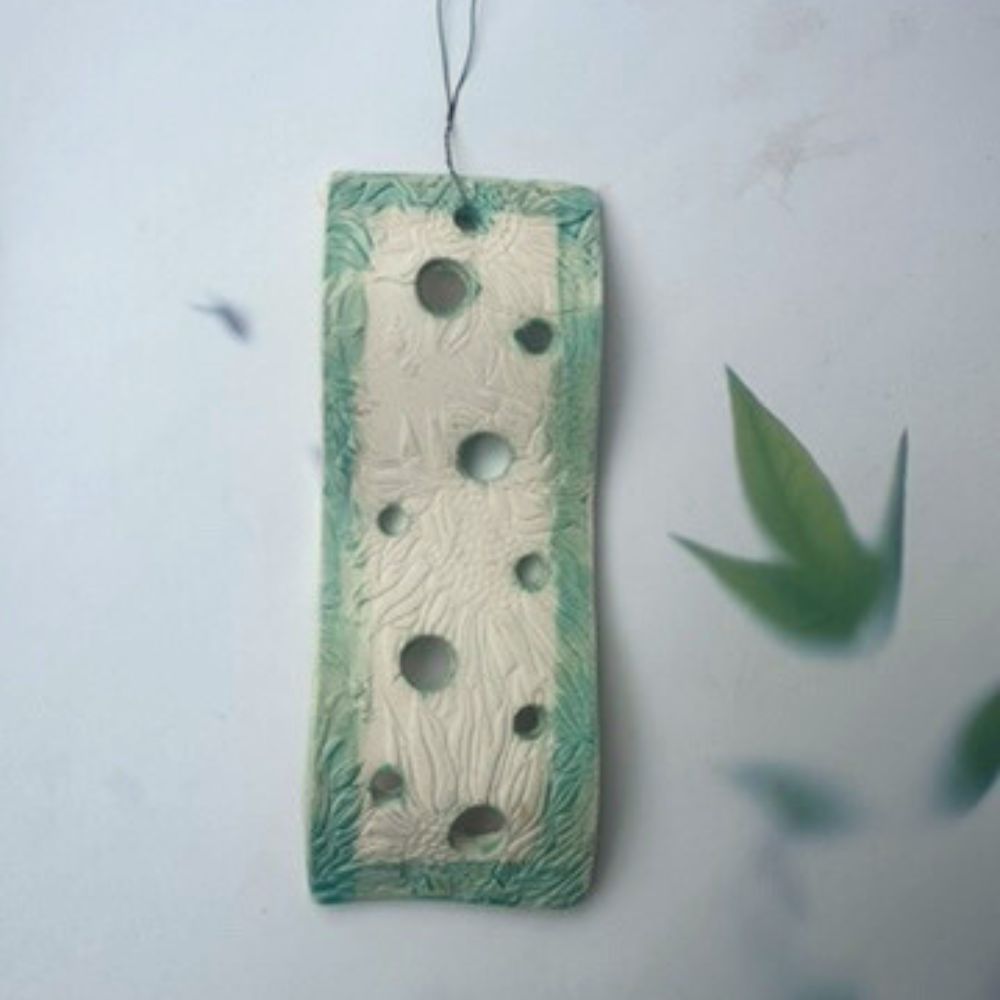A rectangular air plant holders with hole patterns on a light background