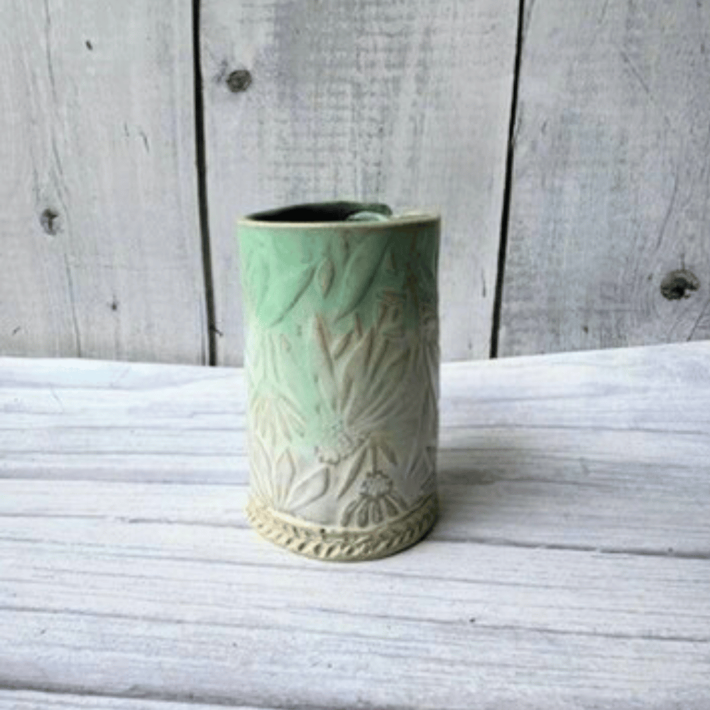 Blue ceramic vase with textured design on a wooden surface