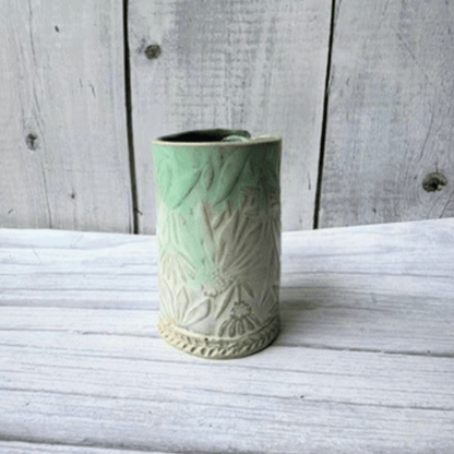 Blue ceramic vase with textured design on a wooden surface