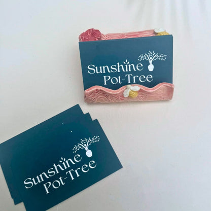 Pink textured business card holder  with floral designs on a white background