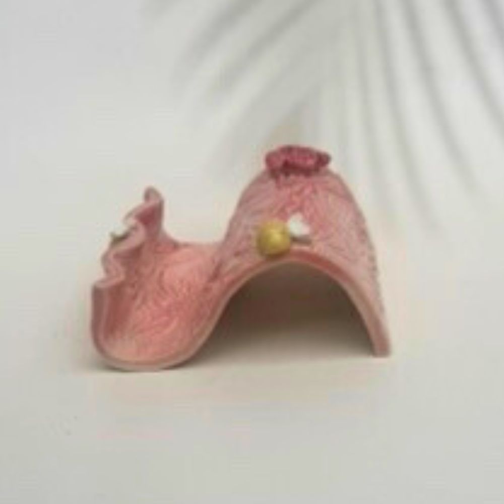 Pink textured business card holder  with floral designs on a white background