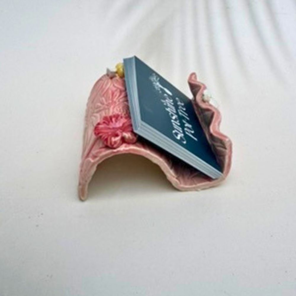 Pink textured business card holder  with floral designs on a white background
