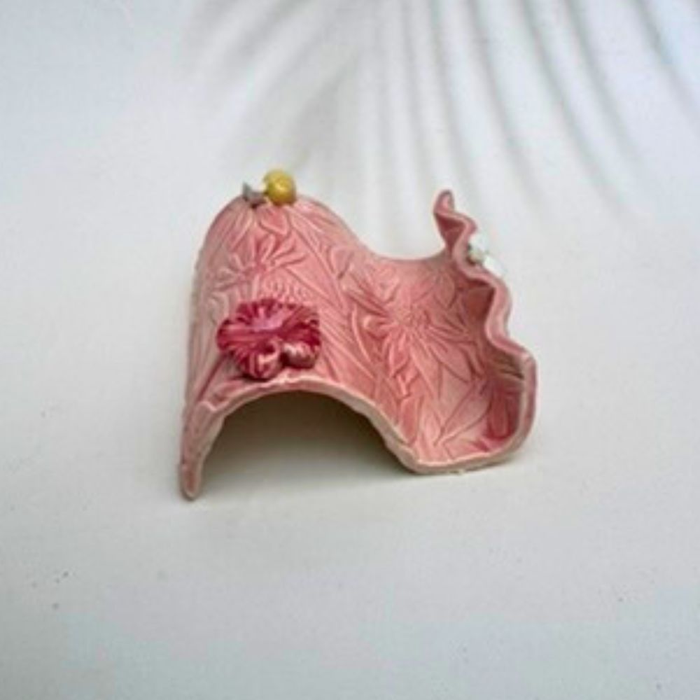 Pink textured business card holder  with floral designs on a white background