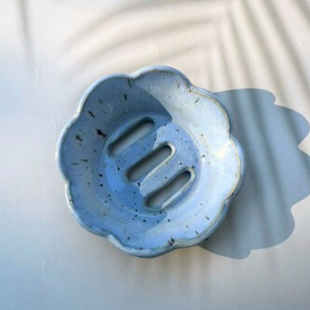 Blue ceramic soap dish with floral design on a light background