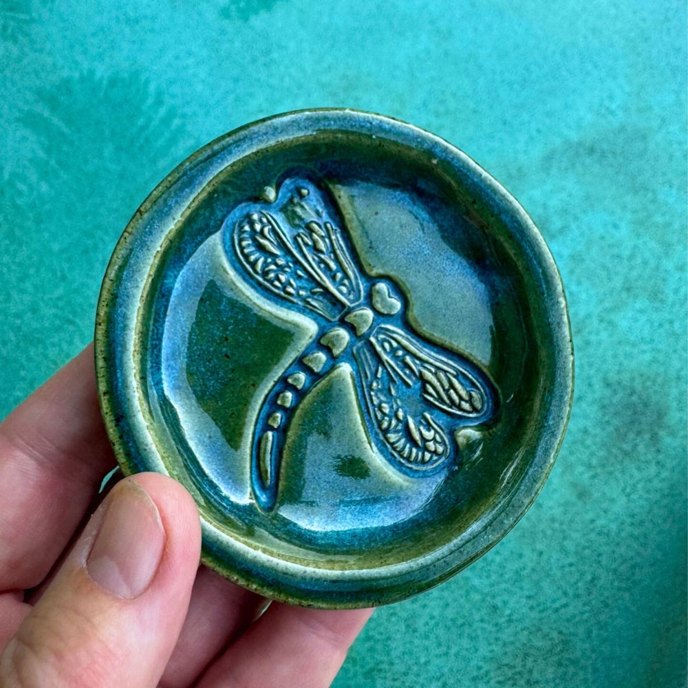 dragonfly imprimt on ring dish over water background