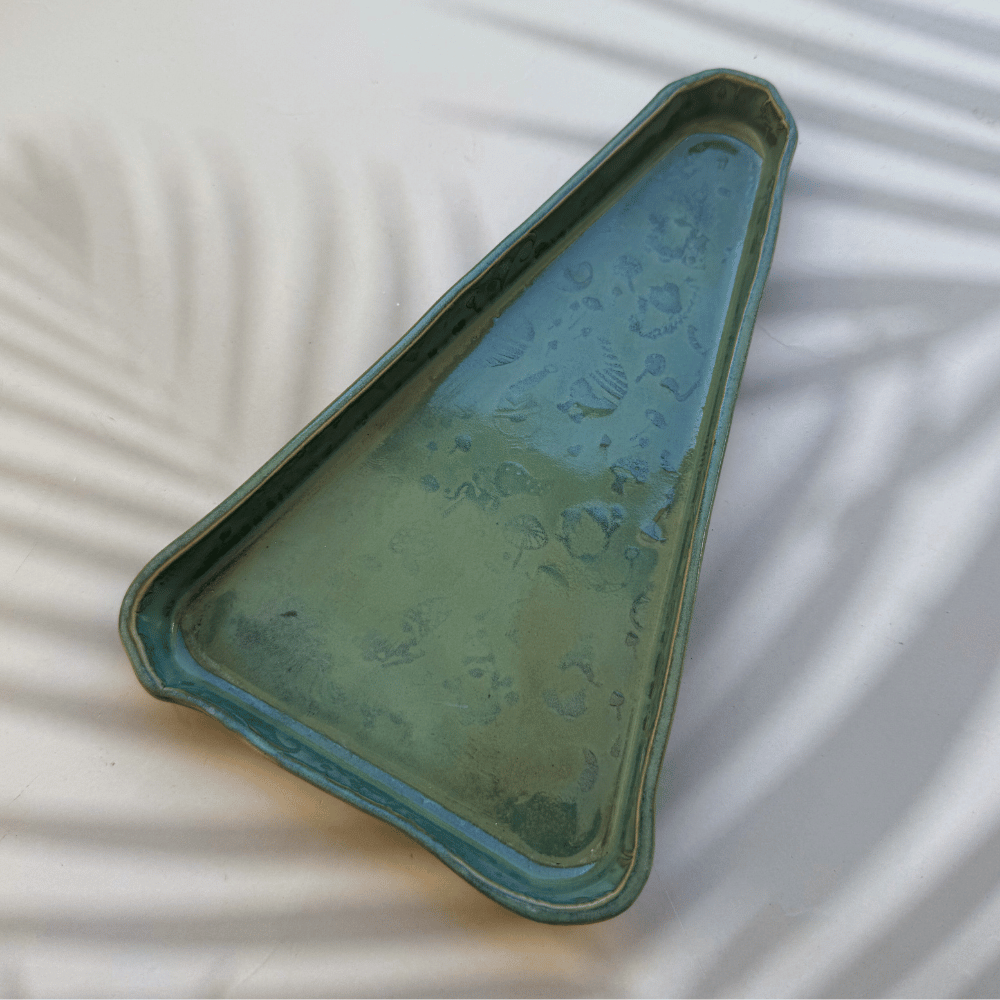 Green ceramic tray on a textured white surface