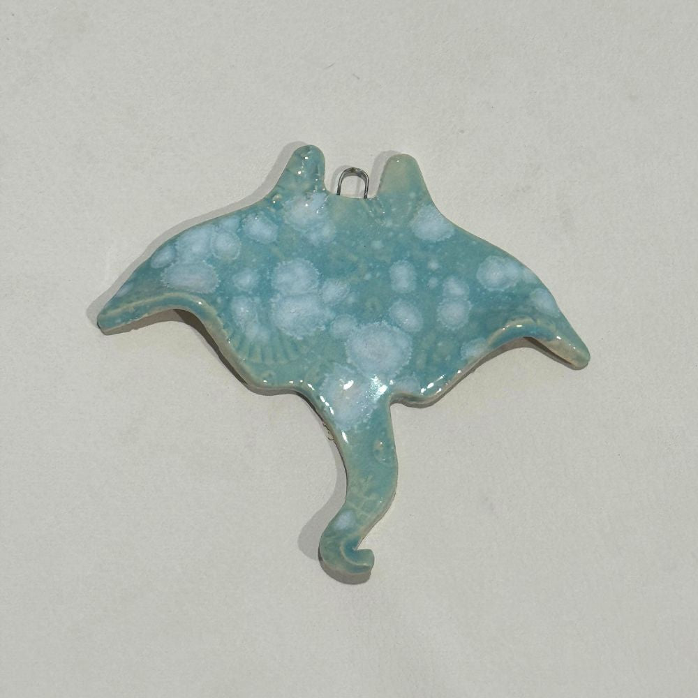 Turquoise ceramic stingray pendant on a light gray background
