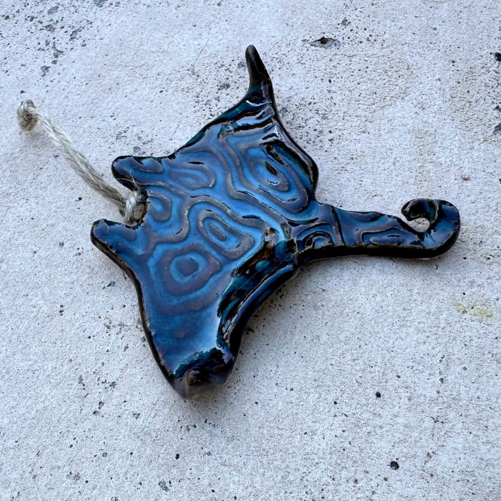 Blue ceramic object with intricate patterns on a gray surface