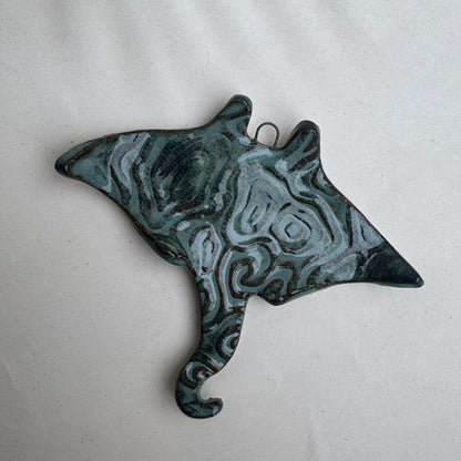 Decorative stingray ornament with a blue and green pattern on a white background
