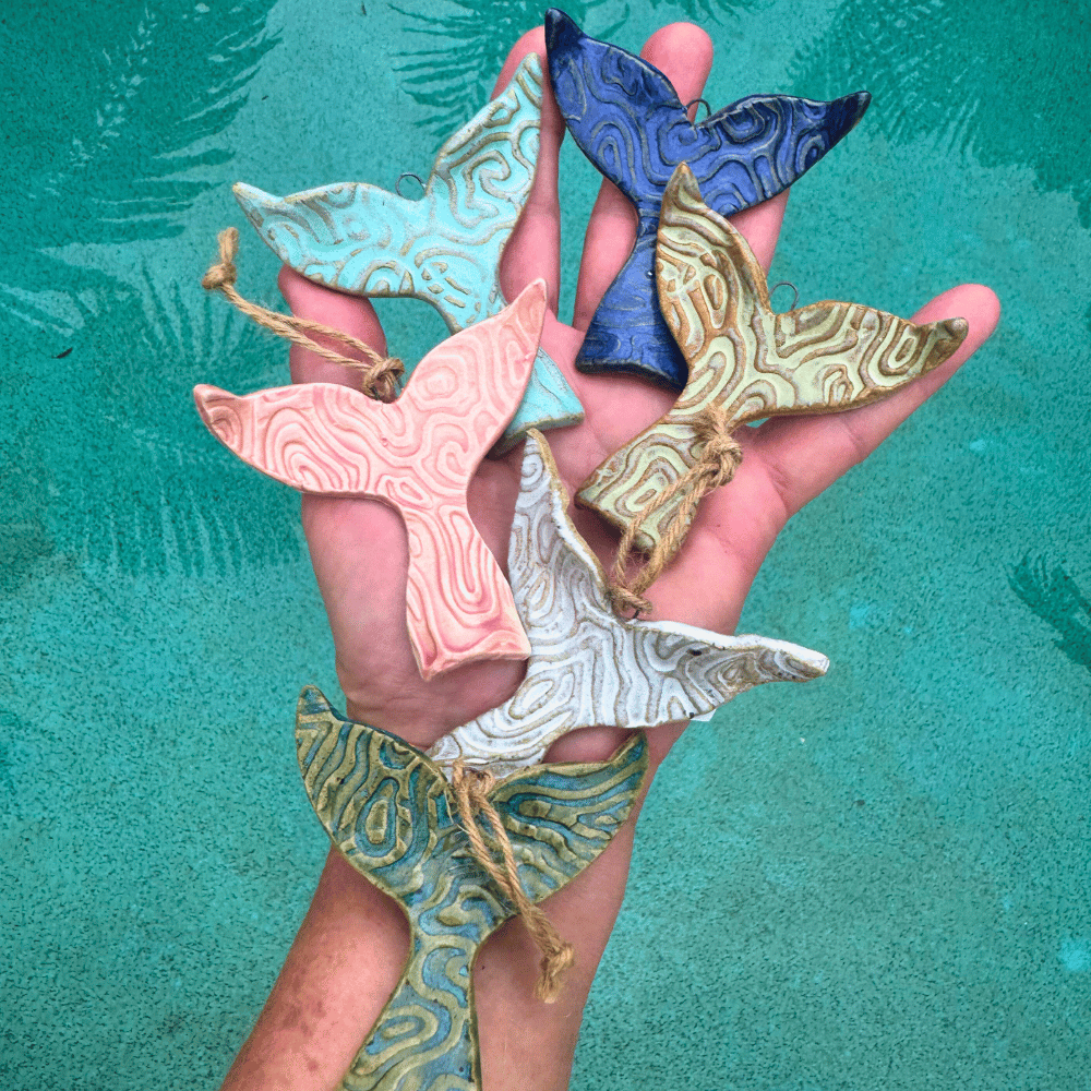 hanging ceramic whale tails held in a hand