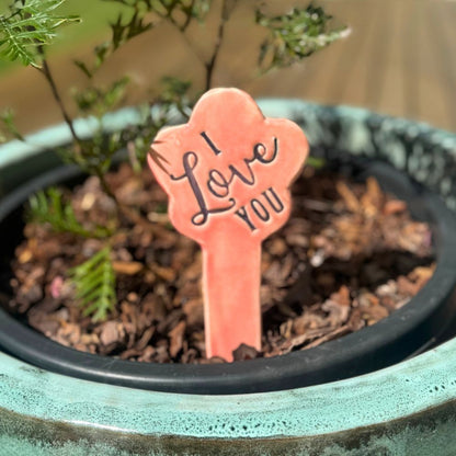 Potted plant with a 'I Love You' sign in a garden setting