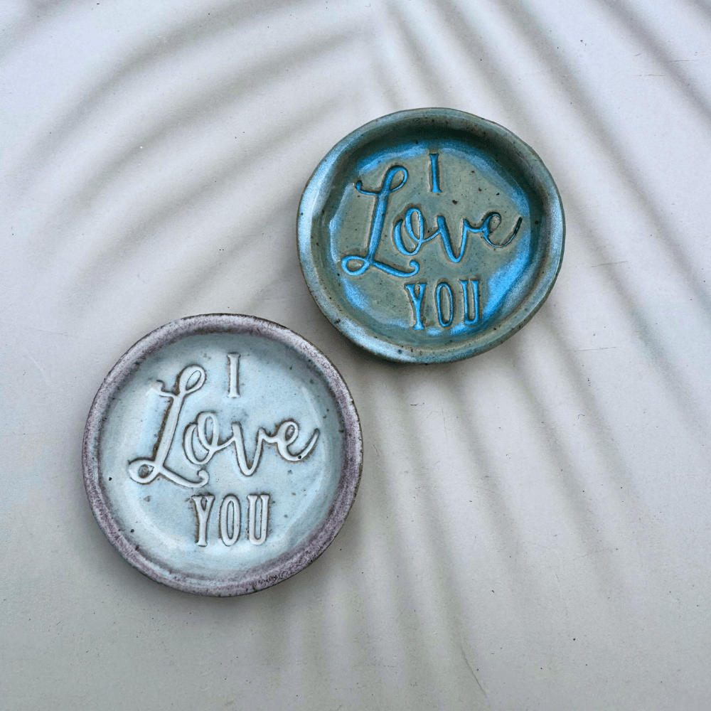 Two ceramic ring dishes with 'I Love You' text on a textured surface