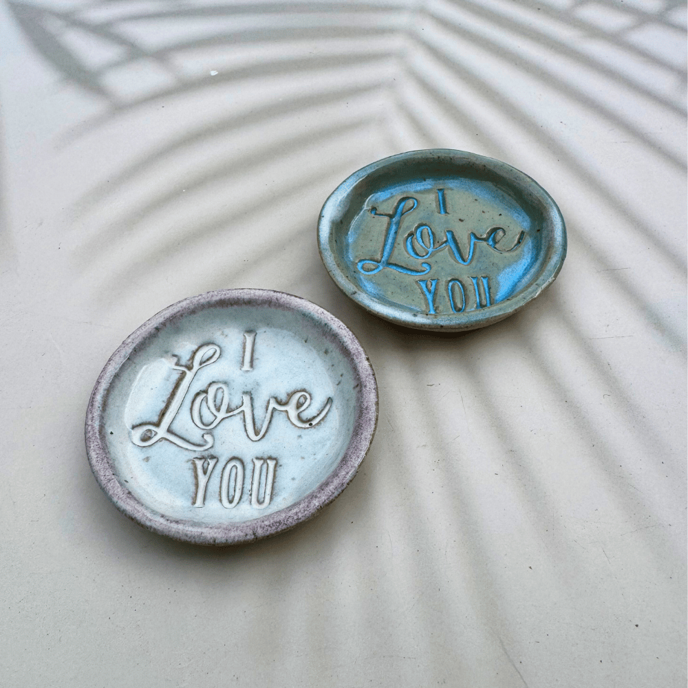 Two ceramic ring dishes with 'I Love You' text on a textured surface