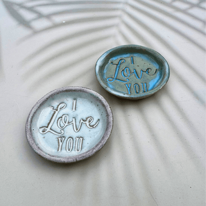 Two ceramic ring dishes with 'I Love You' text on a textured surface