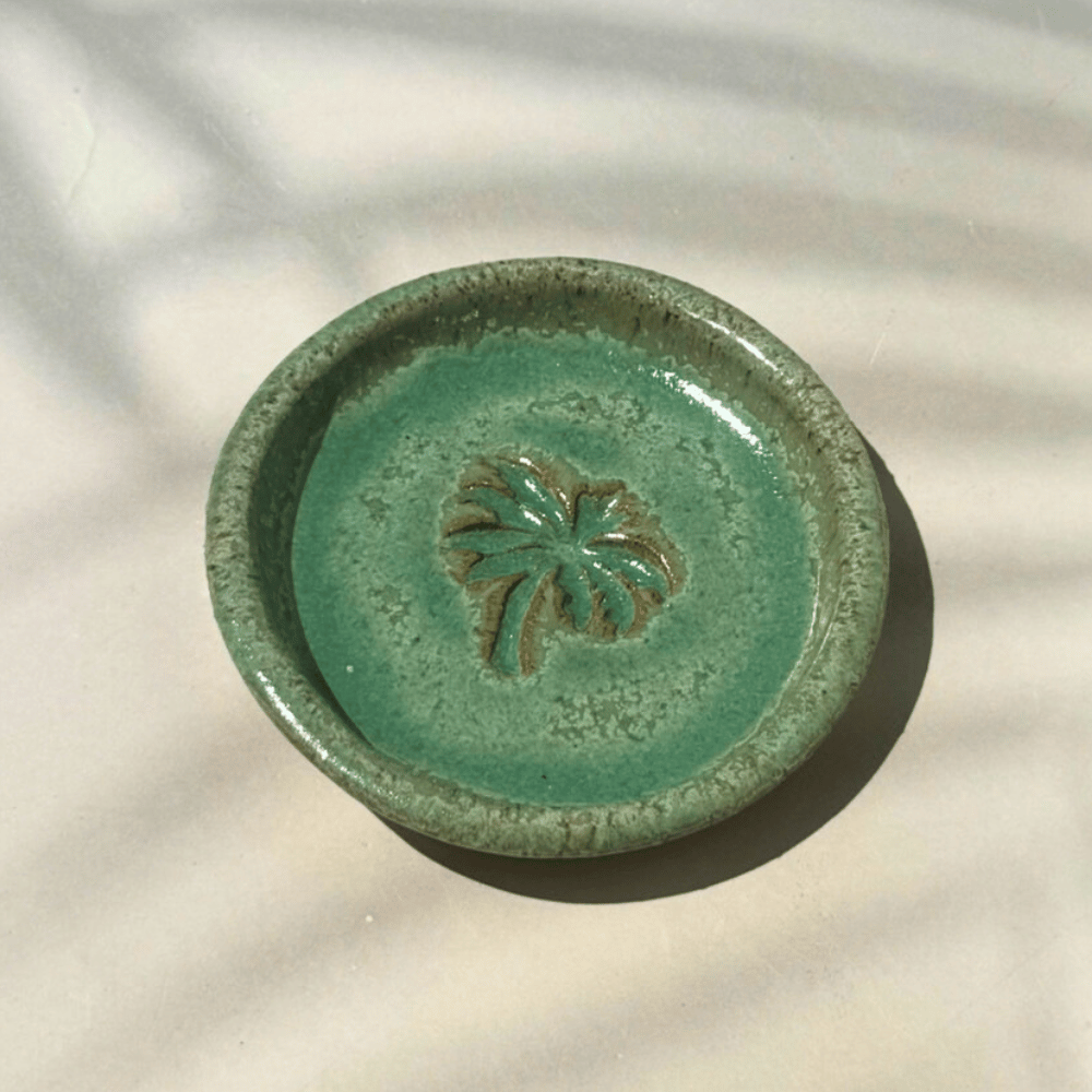 Green ceramic trinket dish with palm tree design on a light background. Sunshine Pot-Tree, Sunshine Coast, Qld.