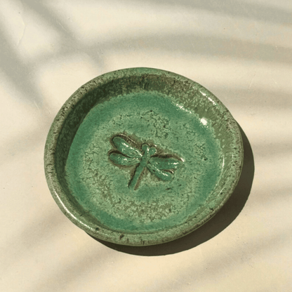 Green ceramic ring dish with a dragonfly design on a beige background. Sunshine Pot-Tree, Sunshine Coast, Qld.