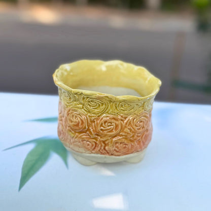 Decorative ceramic pot with floral patterns on a reflective surface