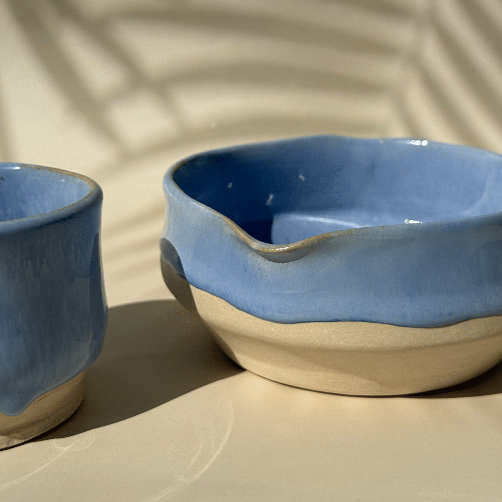 Two lilac ceramic matcha bowls on a beige surface with a soft shadow.
