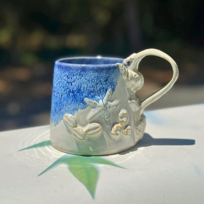 Ceramic mug with starfish design on a white surface