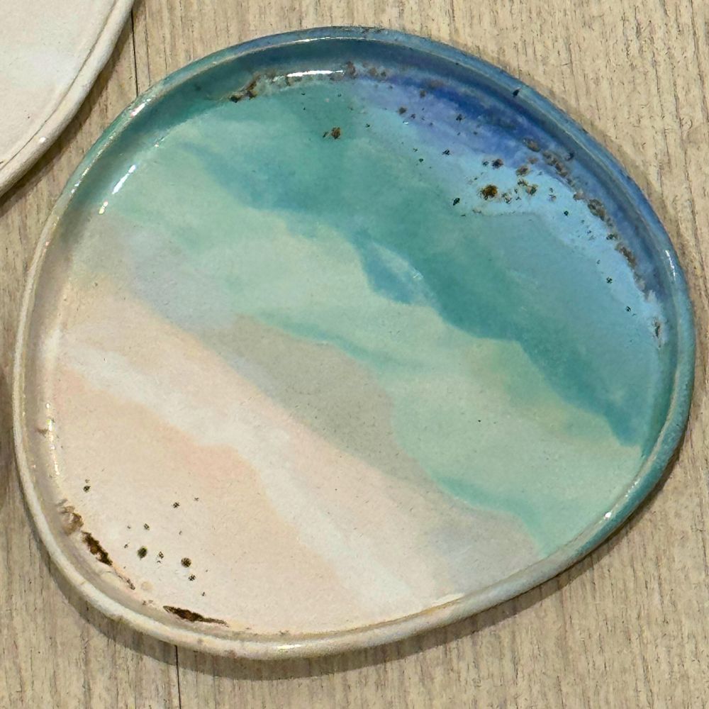 Ceramic plate with blue and green glaze on a wooden surface