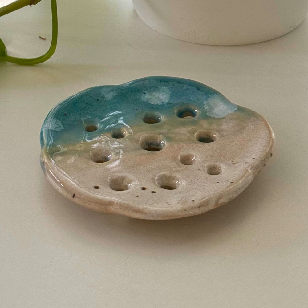 Ceramic soap dish with blue and beige gradient on a light surface