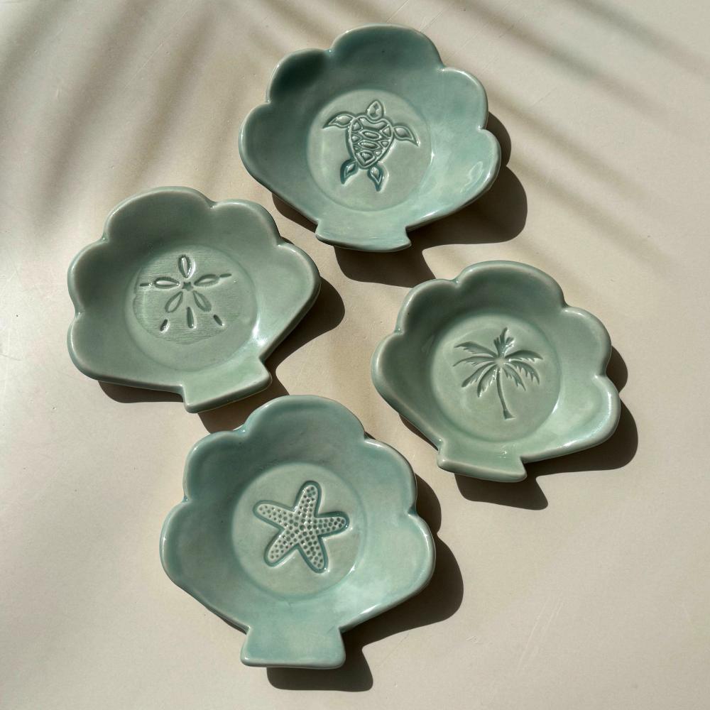 ceramic dishes in the shape of a shell with tropical imprints
