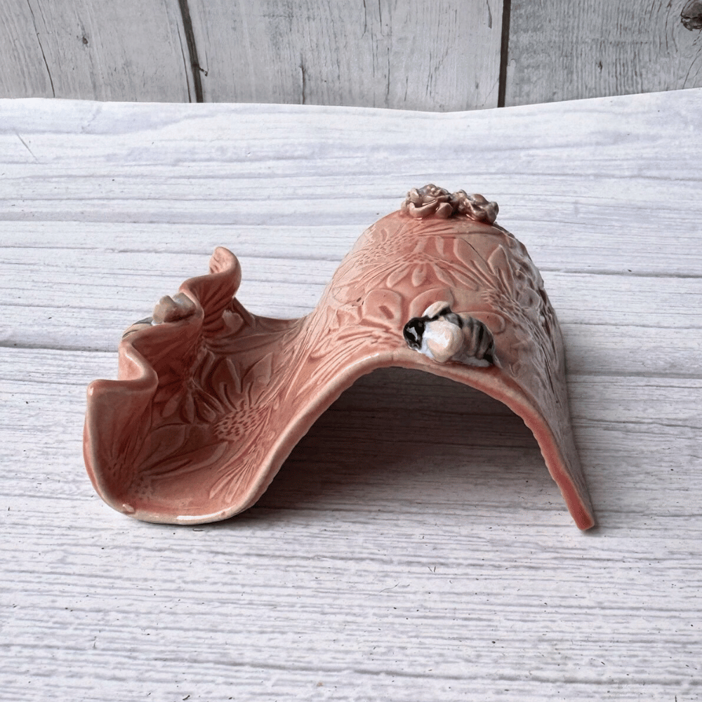 Ceramic business card holder with floral patterns on a wooden surface