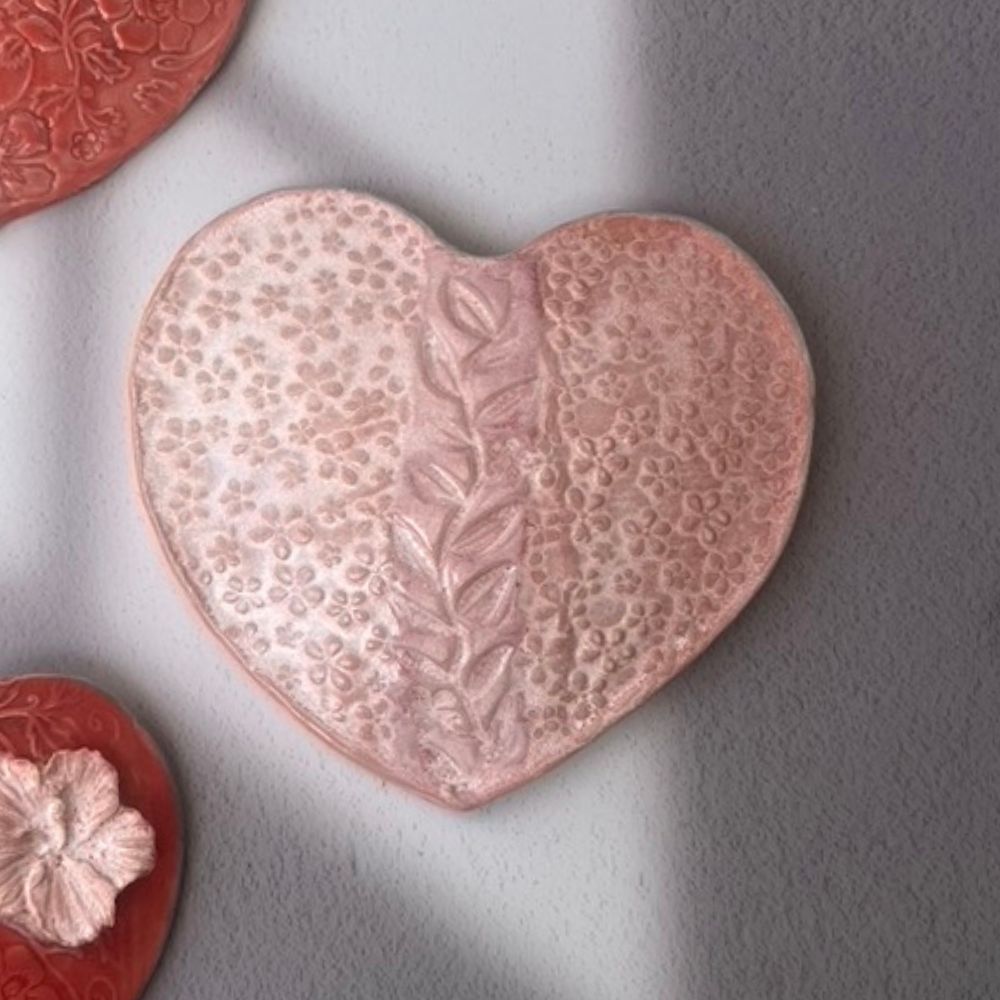 Heart-shaped decorative item with floral patterns on a gray background