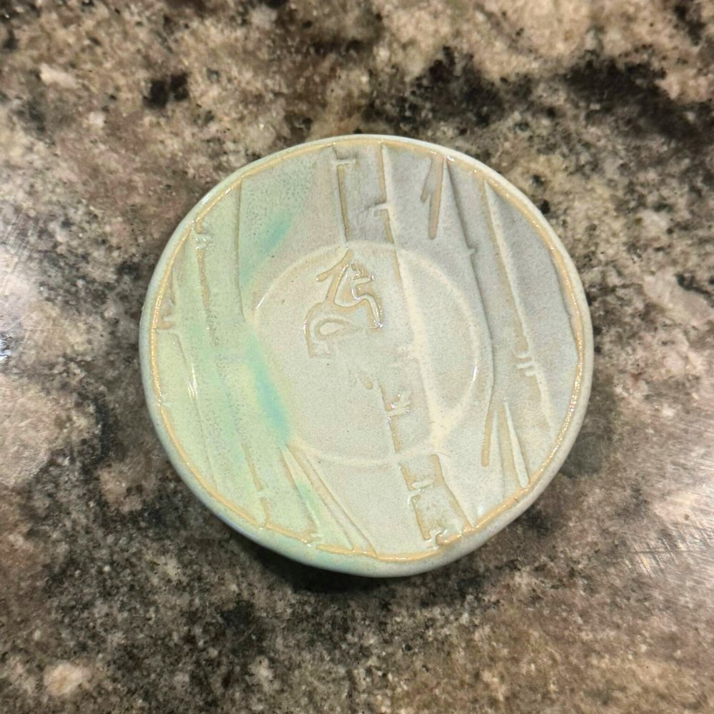 Ceramic ring dish with embossed design on a textured beige background. Sunshine Pot-Tree