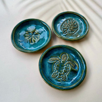 Three blue ceramic dishes with embossed designs on a light background